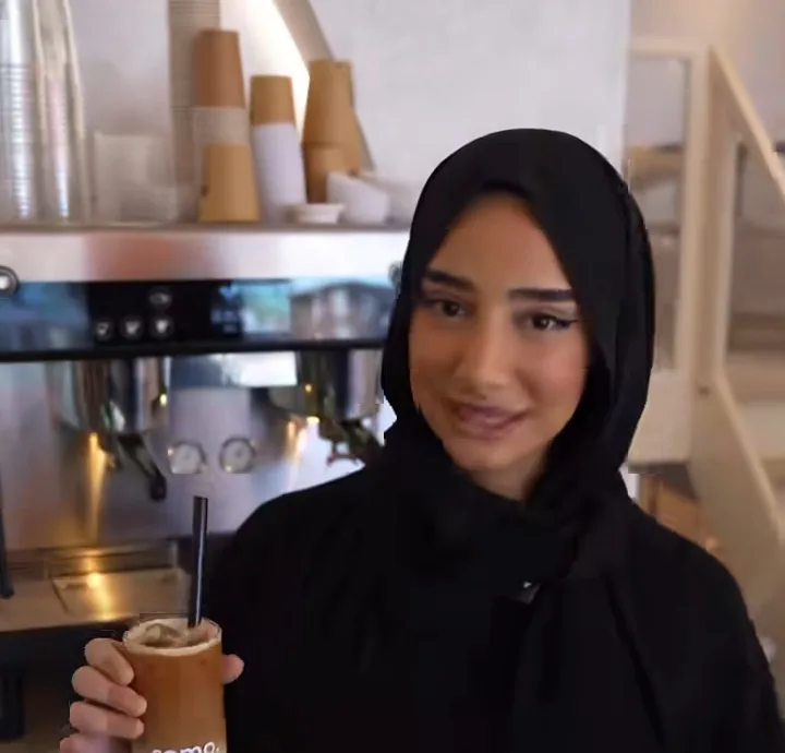 Een gast bestelt aan de bar met een gemerkte COMO-beker in haar hand