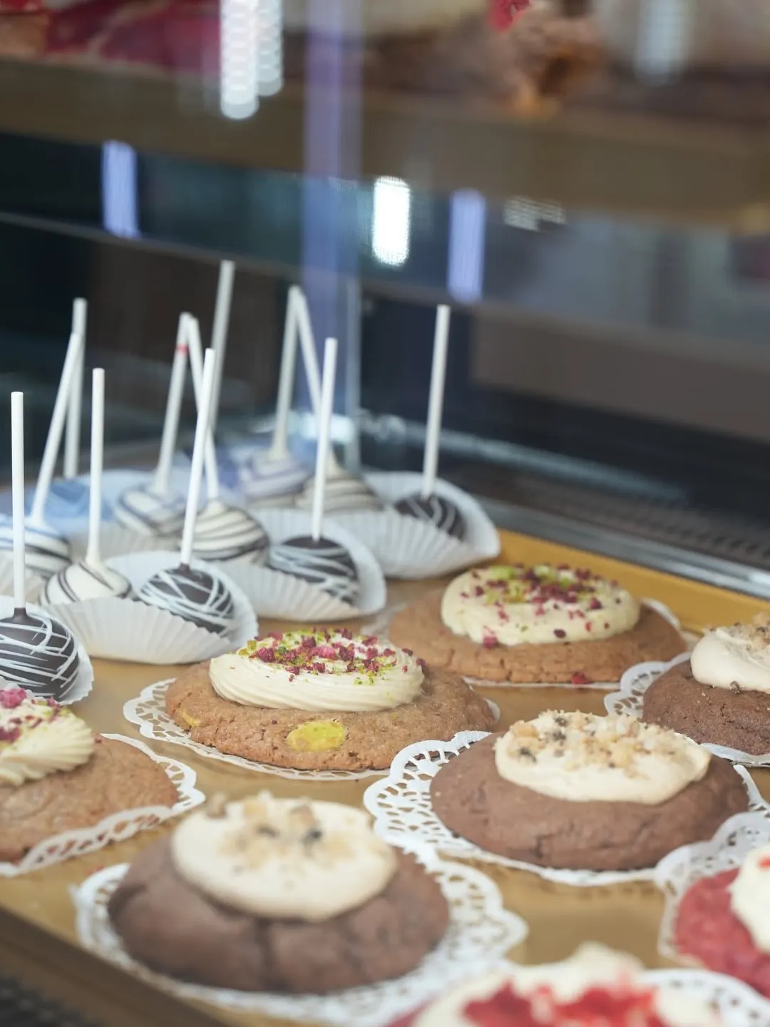 Cookies met roomtoef en cakepops in de vitrine van COMO