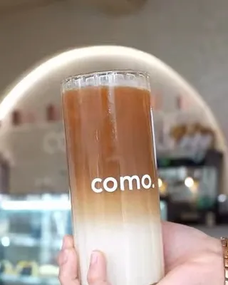 Een ijskoffie in een gemerkt COMO-glas voor de verlichte boog
